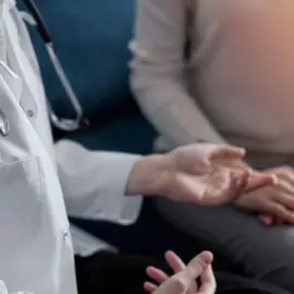 Doctor and patient are sitting and discussing something at sofa in the clinic office